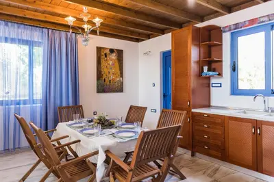 a dining room with a table with chairs and a sink at Lianas Garden House in Rhodes Town
