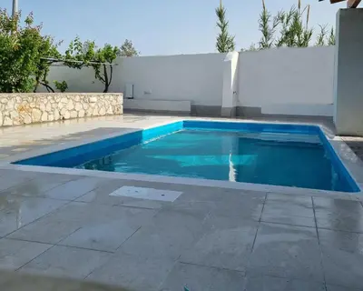 a swimming pool with blue water in a backyard at Lianas Garden House in Rhodes Town