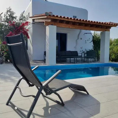 a black chair sitting next to a swimming pool at Lianas Garden House in Rhodes Town