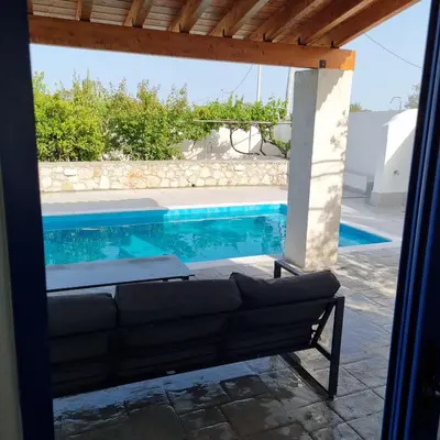 a couch in front of a swimming pool at Lianas Garden House in Rhodes Town