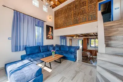 a living room with a blue couch and a table at Lianas Garden House in Rhodes Town