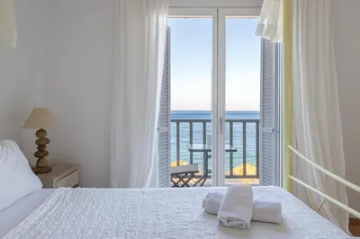 a bedroom with a bed and a view of the ocean at Uno Luxury Apartment with Sea view in Livadia