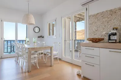 a kitchen and dining room with a table and chairs at Uno Luxury Apartment with Sea view in Livadia