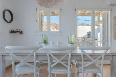a white dining room with a table and chairs at Uno Luxury Apartment with Sea view in Livadia