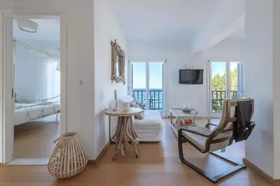 a living room with a chair and a table at Uno Luxury Apartment with Sea view in Livadia