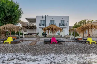 a resort with colorful chairs and umbrellas on the beach at Uno Luxury Apartment with Sea view in Livadia