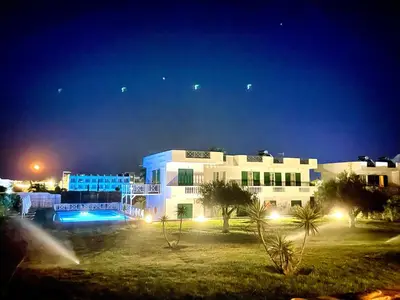 a large white building at night with lights at Villa Rizia in Kolimbia