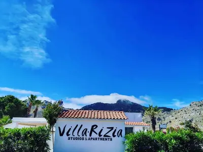 a sign for a building with a mountain in the background at Villa Rizia in Kolimbia