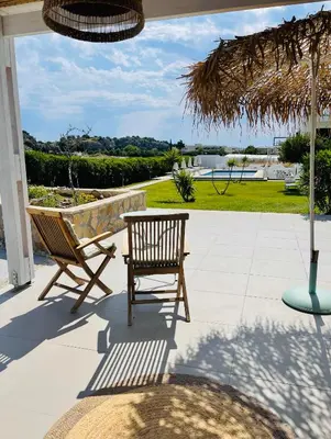 a patio with two chairs and an umbrella at Villa Rizia in Kolimbia