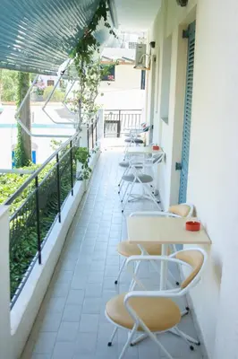 a row of tables and chairs on a balcony at George Apartments in Livadia