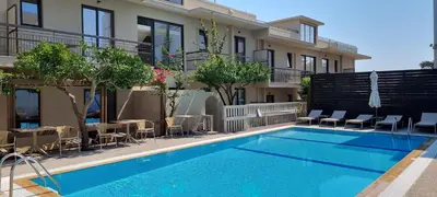 a swimming pool in front of a building at Mariette Rhodes Urban Suites in Rhodes Town