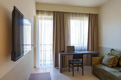 a hotel room with a desk with a computer and a couch at Mariette Rhodes Urban Suites in Rhodes Town