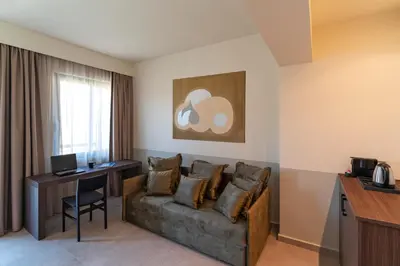 a living room with a couch and a table and a desk at Mariette Rhodes Urban Suites in Rhodes Town