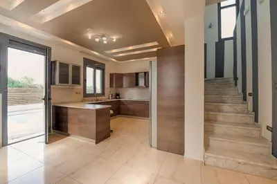 a large kitchen with a staircase in a house at Villa Pandesia in Kremasti