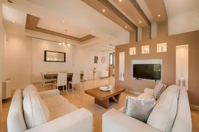 a living room with white furniture and a dining room at Villa Pandesia in Kremasti
