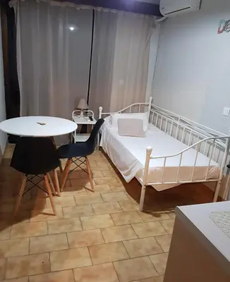 a bedroom with a bed and a table and chairs at Emerald Dream House,Heart of the City Center in Rhodes Town