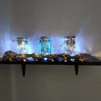 a shelf with three glass jars and a garland at Emerald Dream House,Heart of the City Center in Rhodes Town