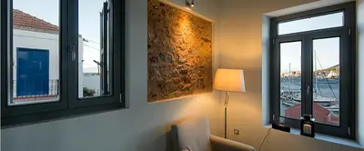 a room with two windows and a lamp and a chair at Villa Kalypso in Halki
