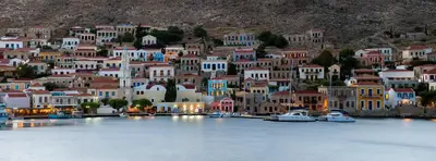 a town on a hill with boats in the water at Villa Kalypso in Halki