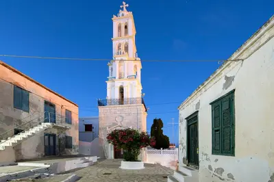 a tall clock tower in a town with buildings at Villa Kalypso in Halki