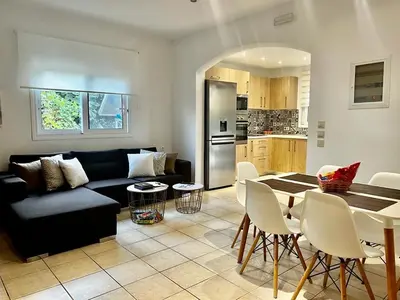 a living room with a black couch and a table at Olive Sense Villa with jacuzzi and sauna in Afantou