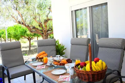 a table with a basket of fruit on it at Olive Sense Villa with jacuzzi and sauna in Afantou