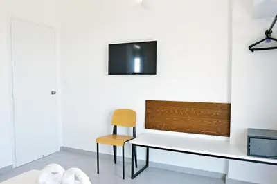 a dining room with a white table and a chair at Hillside Studios & Apartments in Faliraki