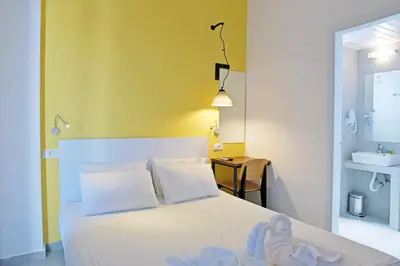 a bedroom with a white bed and a sink at Hillside Studios & Apartments in Faliraki