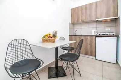 a kitchen with two chairs and a table with fruit on it at Hillside Studios & Apartments in Faliraki