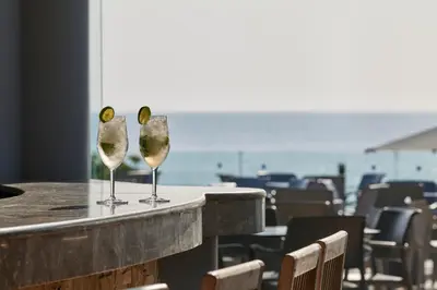 two wine glasses sitting on a table in a restaurant at Esperos Mare Resort & Spa in Faliraki