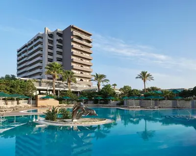 a resort swimming pool with a hotel in the background at Esperos Mare Resort & Spa in Faliraki