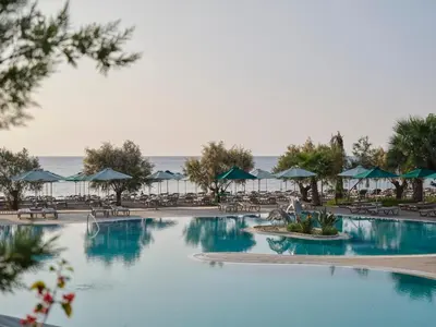 a pool at a resort with chairs and umbrellas at Esperos Mare Resort & Spa in Faliraki