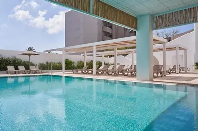 a swimming pool with chairs and a building at Epsilon Hotel Apartments in Faliraki