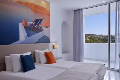 a hotel room with a bed and a large window at Epsilon Hotel Apartments in Faliraki