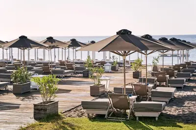 a row of chairs and umbrellas on a beach at Epsilon Hotel Apartments in Faliraki