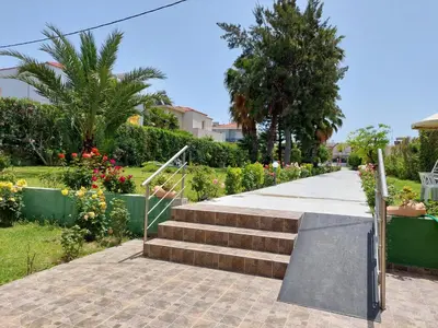 a set of stairs leading to a garden with flowers at Alexia Apartments & Studios in Kremasti