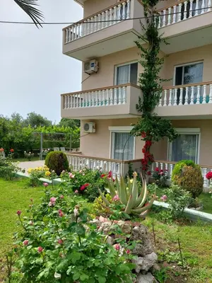 a building with a flower garden in front of it at Alexia Apartments & Studios in Kremasti