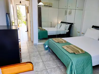 a hotel room with two beds and a television at Alexia Apartments & Studios in Kremasti