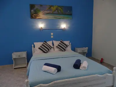 a blue bedroom with a bed with towels on it at Alexia Apartments & Studios in Kremasti