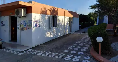 a small white building with a shadow on the side of it at Kyriakos Studios in Afantou