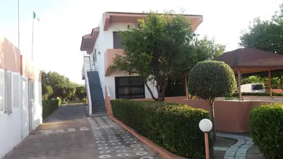 a house with a walkway in front of a building at Kyriakos Studios in Afantou