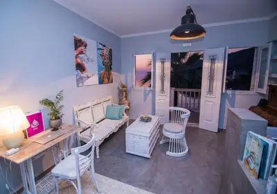 a living room with a couch and a table and chairs at Niriides Hotel Apartments in Symi