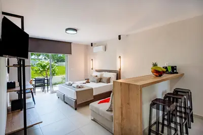 a bedroom with a bed and a living room at Sokrates Studios in Afantou