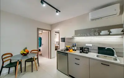 a kitchen with a sink and a table with chairs at Sokrates Studios in Afantou