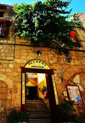 a stone building with a sign that reads unity sqor at Olympos Pension in Rhodes Town