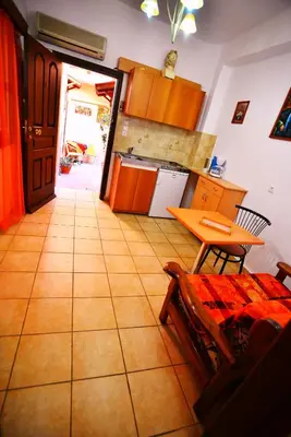 a kitchen with orange cabinets and a table and a table at Olympos Pension in Rhodes Town