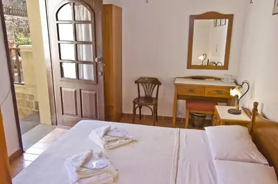 a bedroom with a bed and a desk and a mirror at Camelot Traditional & Classic Hotel in Rhodes Town