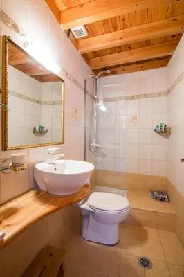 a bathroom with a sink and a toilet and a mirror at Camelot Traditional & Classic Hotel in Rhodes Town