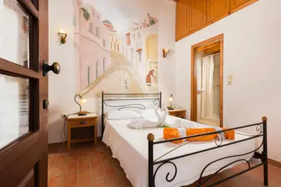 a bedroom with a bed with a painting on the wall at Camelot Traditional & Classic Hotel in Rhodes Town