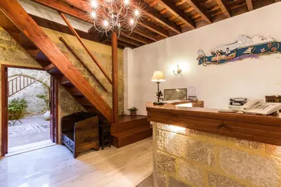 an attic office with a stone wall and a desk at Camelot Traditional & Classic Hotel in Rhodes Town